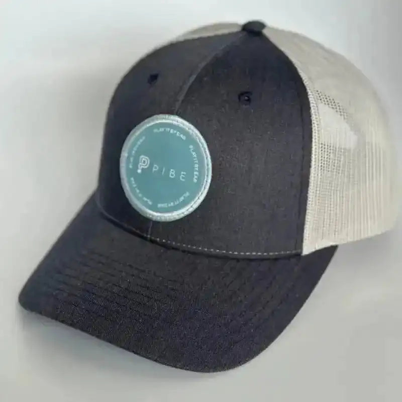 Navy cap with a green PIBE logo on a light gray background