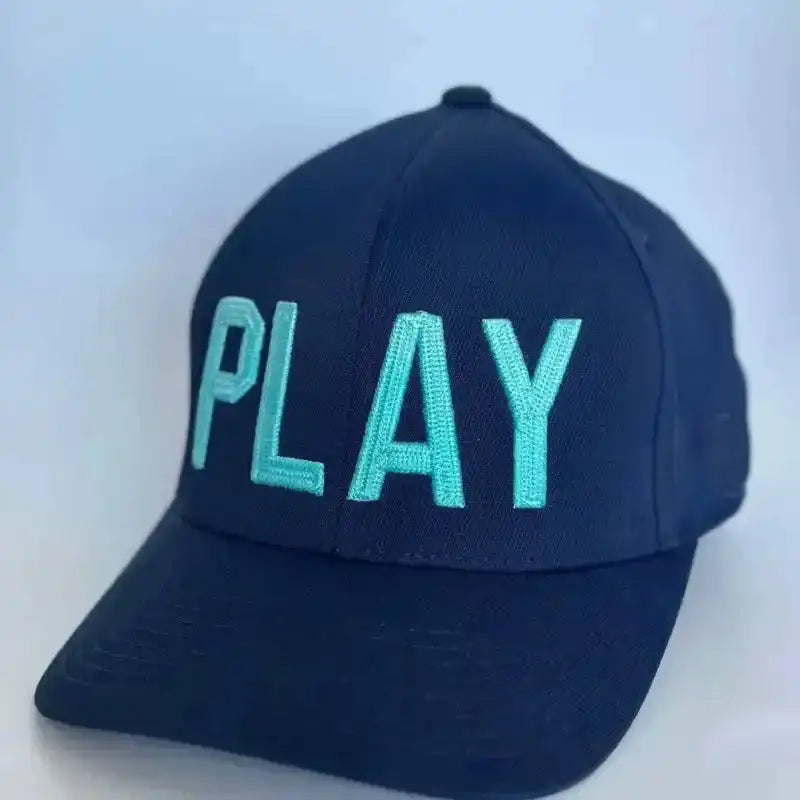 Navy blue cap with 'PLAY' in light blue on a light gray background